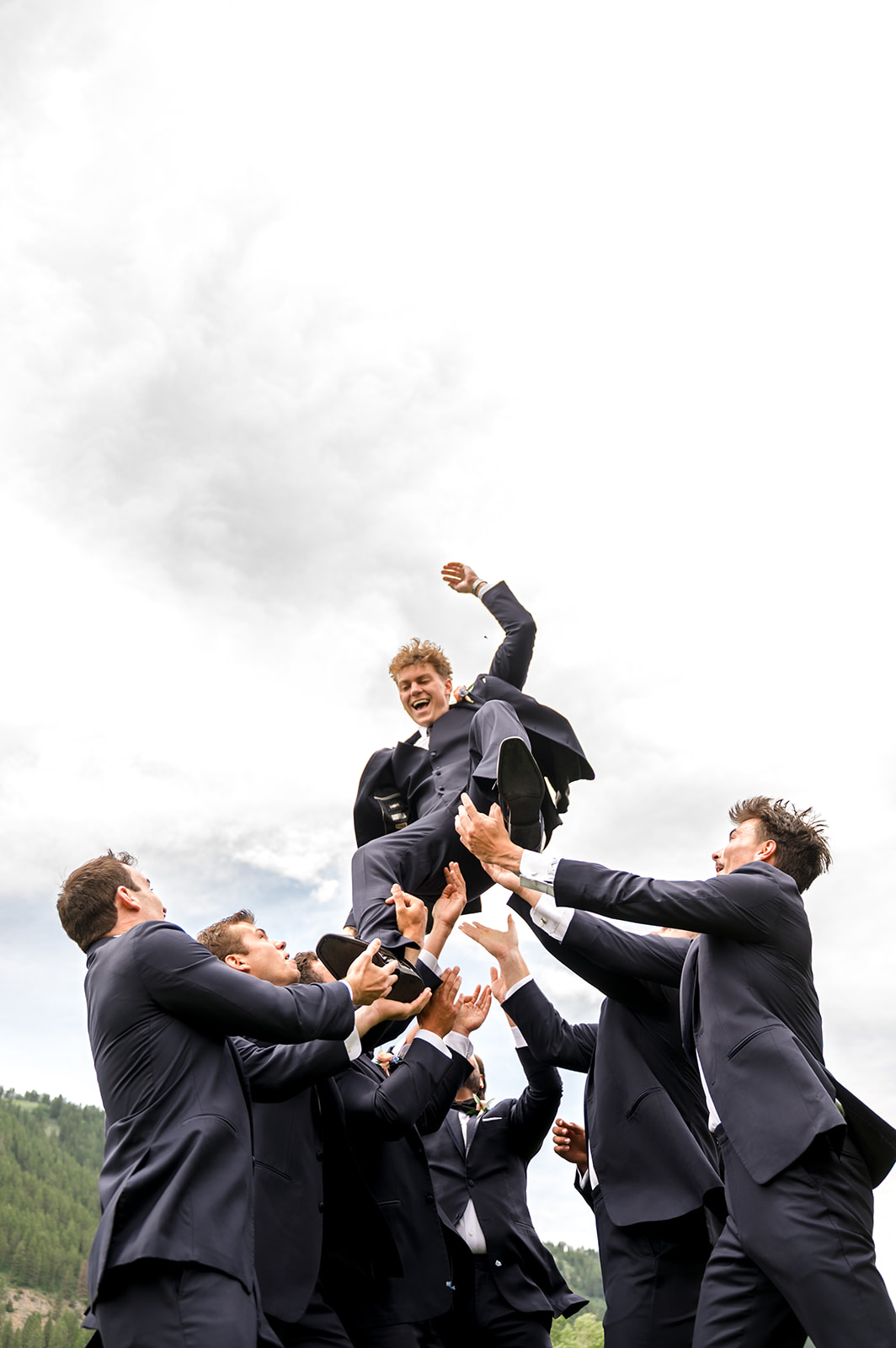 Groomsmen tossing the groom in the air
