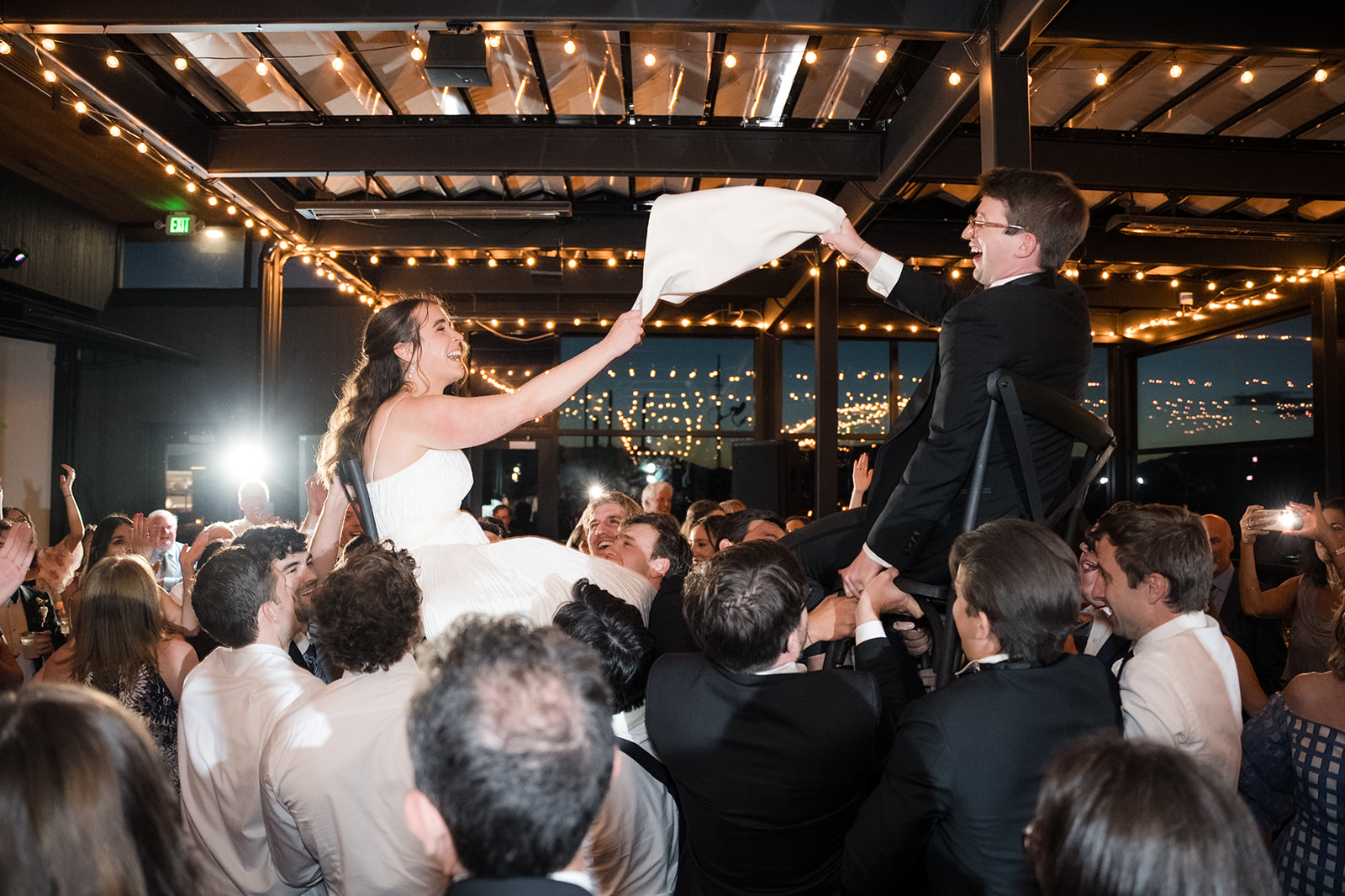 Bride and groom lifted on chairs during the reception hora